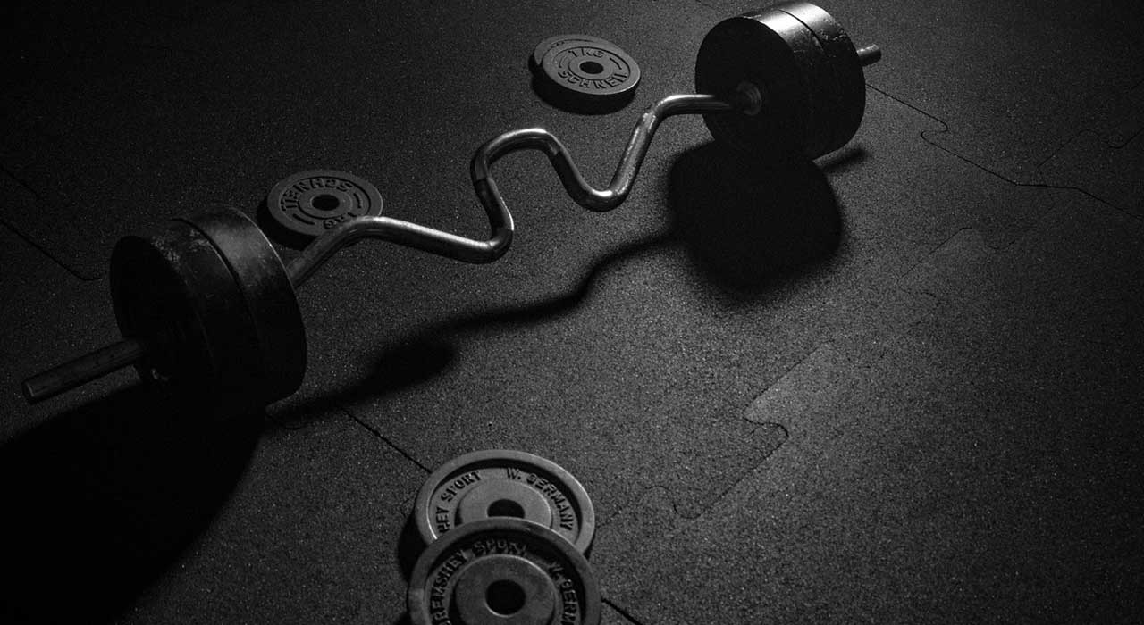 super ex curl bar and weights on a gym floor