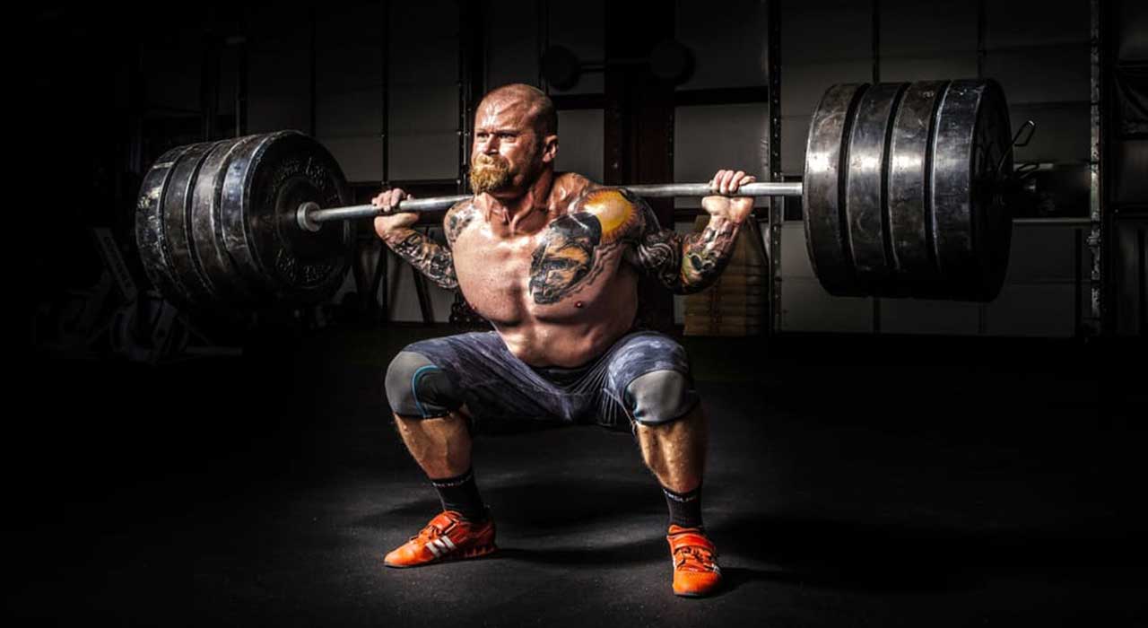 muscular heavyweight lifter squatting a heavy weight