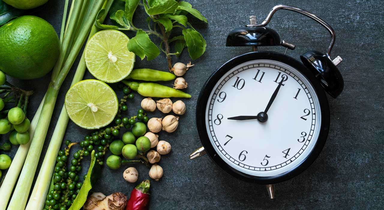 fruit and vegetables around an alarm clock