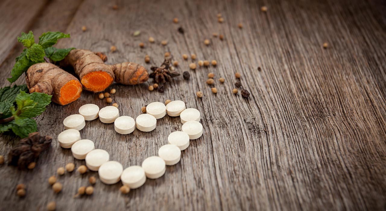 medication pills in the shape of a heart next to some vegetables