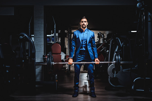 man in full suit performing a deadlift