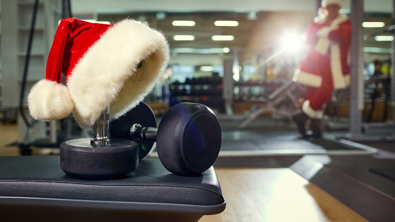 santa hat on top of some dumbbells in the gym with santa in the background
