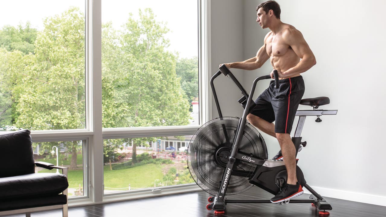 muscular man riding air bike airdyne ad8