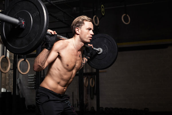 muscular man with a barbell on his back