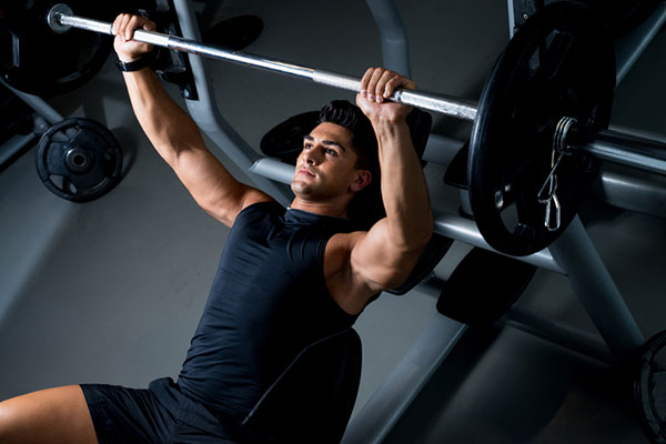 muscular man performing a bench press