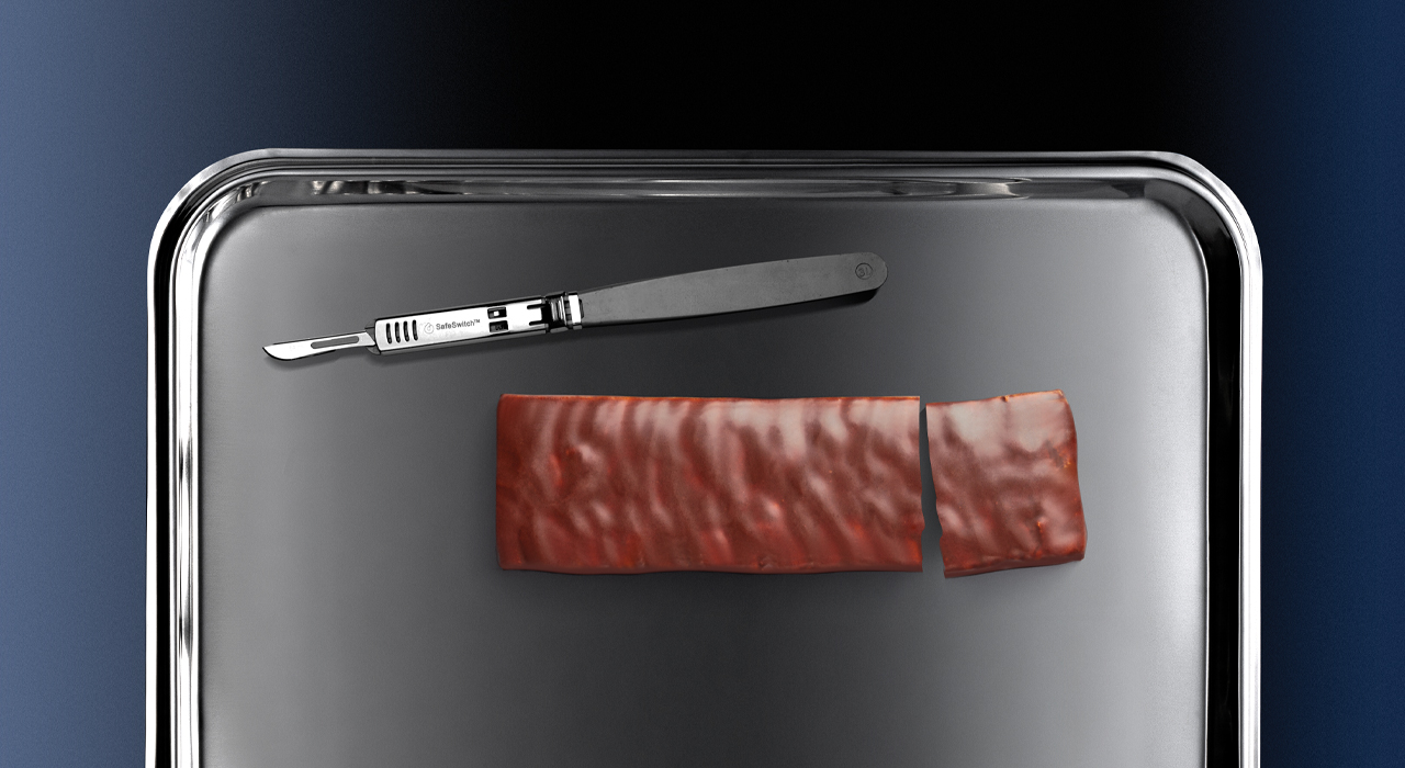 a scalpel next to a protein bar