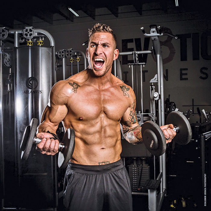 muscular man in gym performing bicep curls