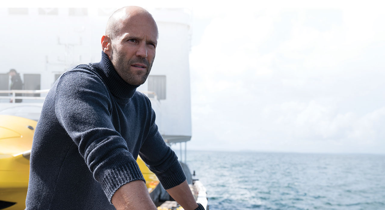 jason statham looking off the side of a ship