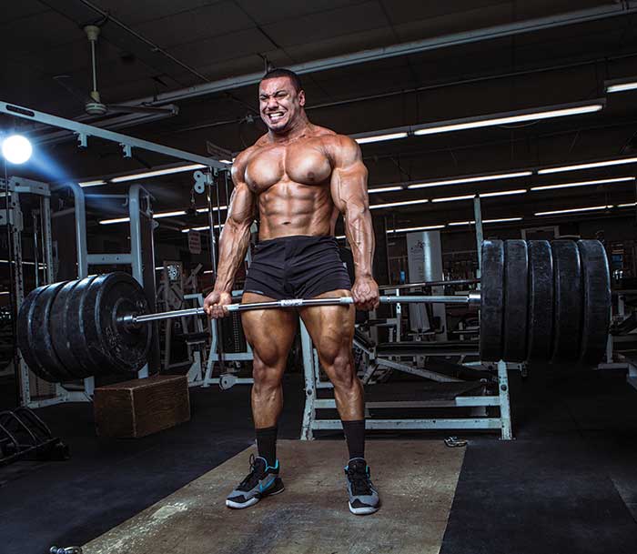 muscular man deadlifting a heavy weight in the gym