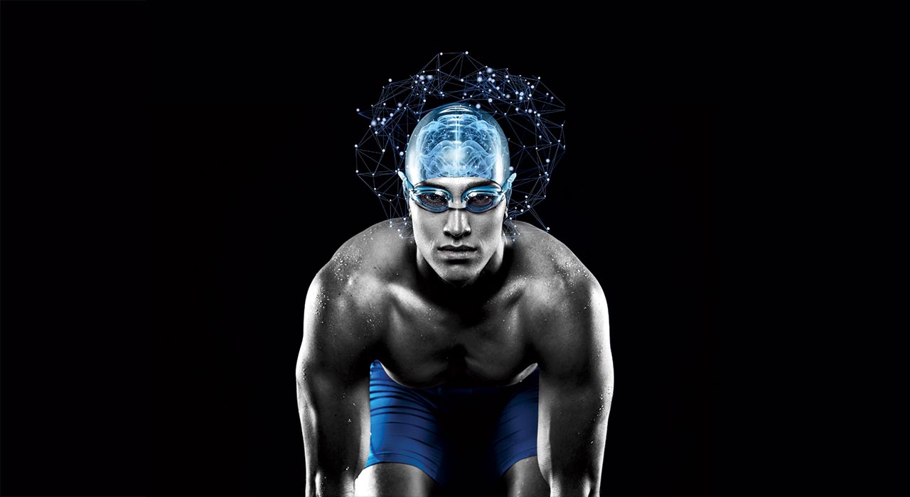 a swimmer preparing to race with a blue swimming cap on