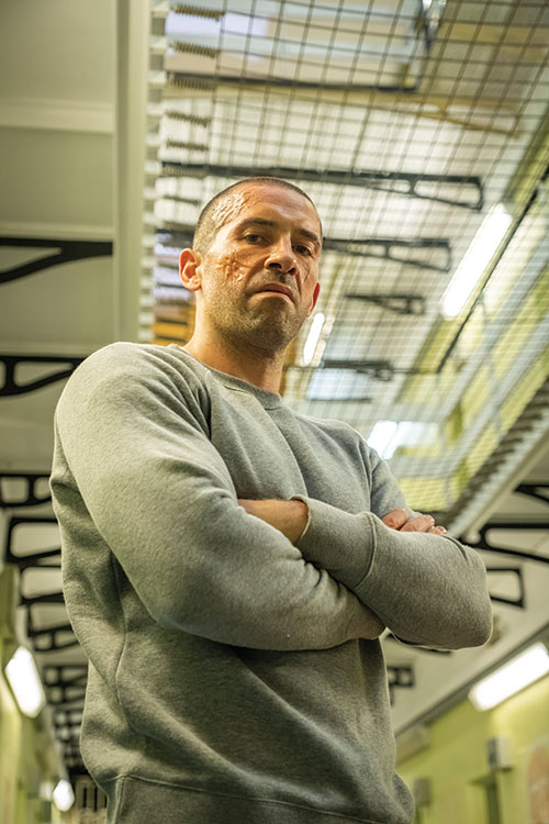 scott adkins posing as an inmate in a prisoner