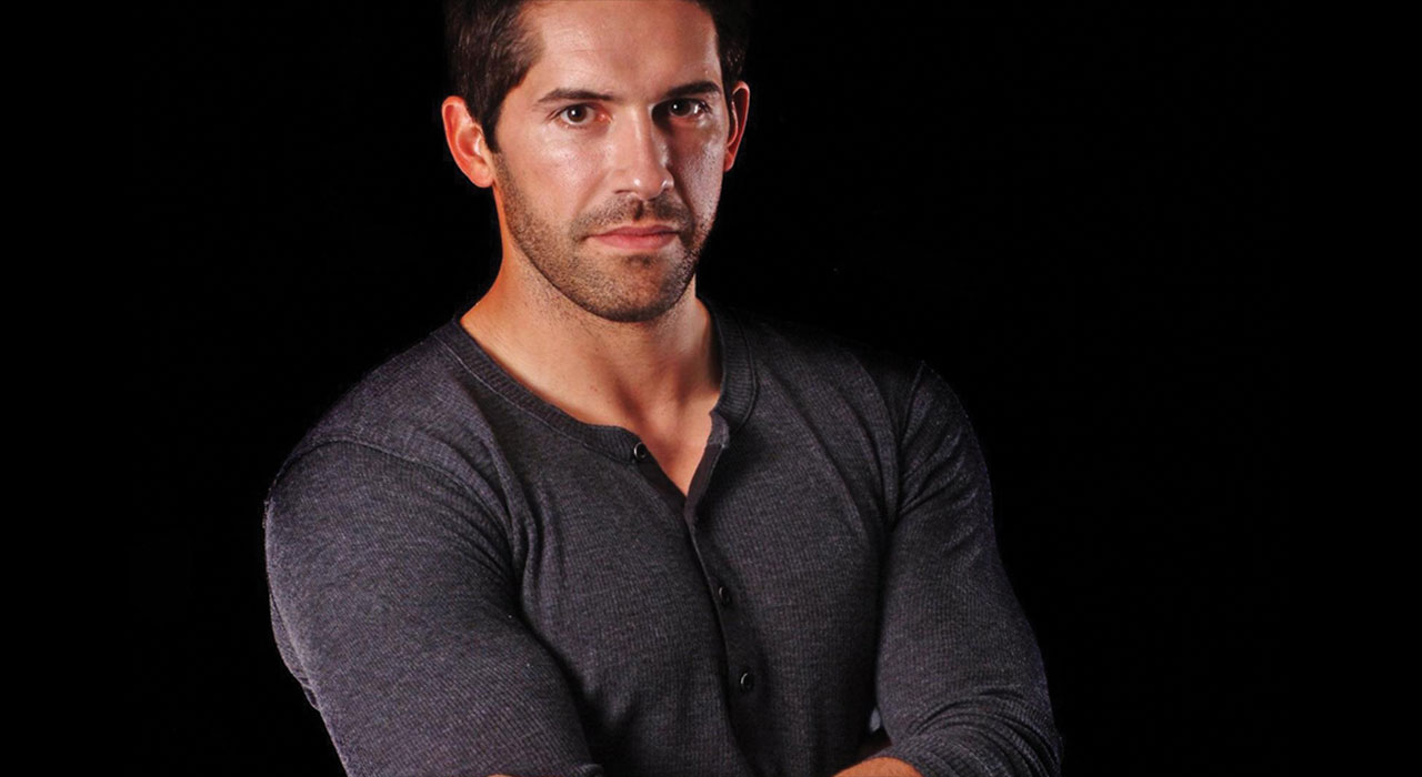 scott adkins with arms folded