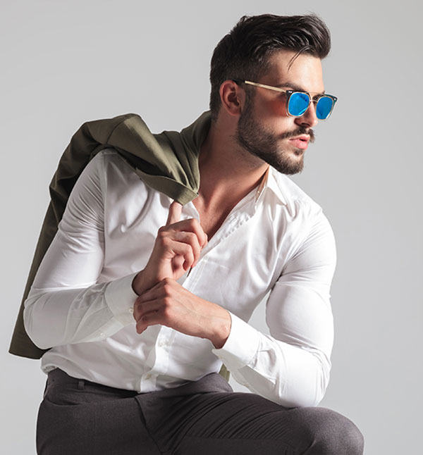 fit man wearing suit pants and shirt with sunglasses on and jacket over shoulder