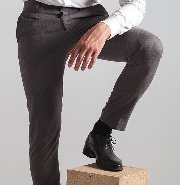 man with leg up on box in suit pants