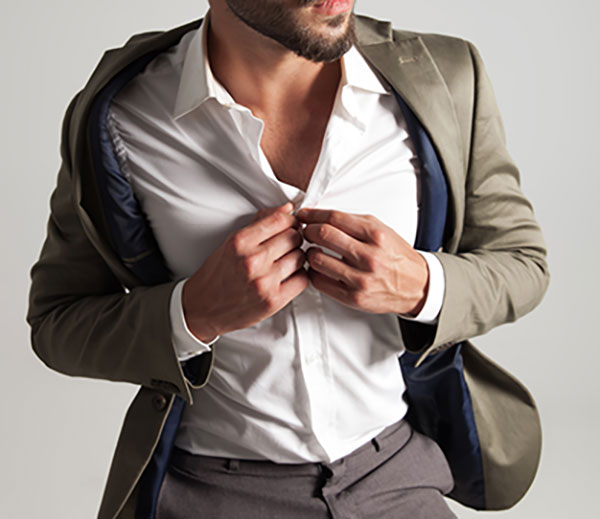 man wearing suit unbuttoning his shirt