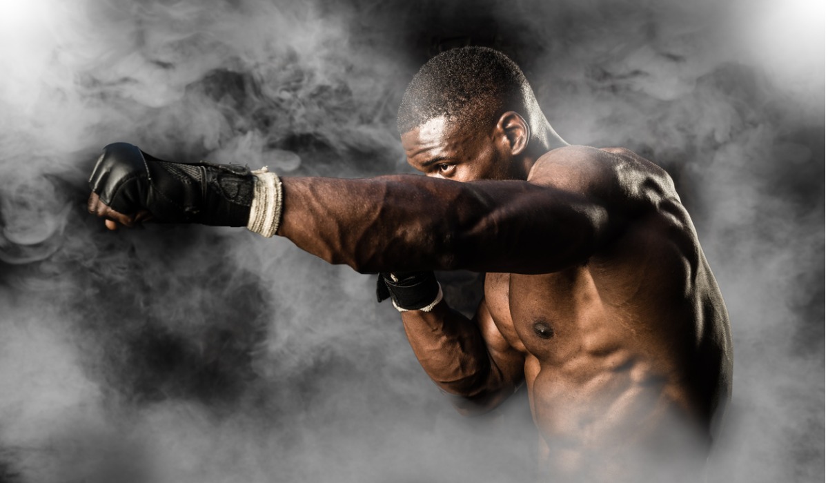 muscular man shadow boxing with white smoke around him