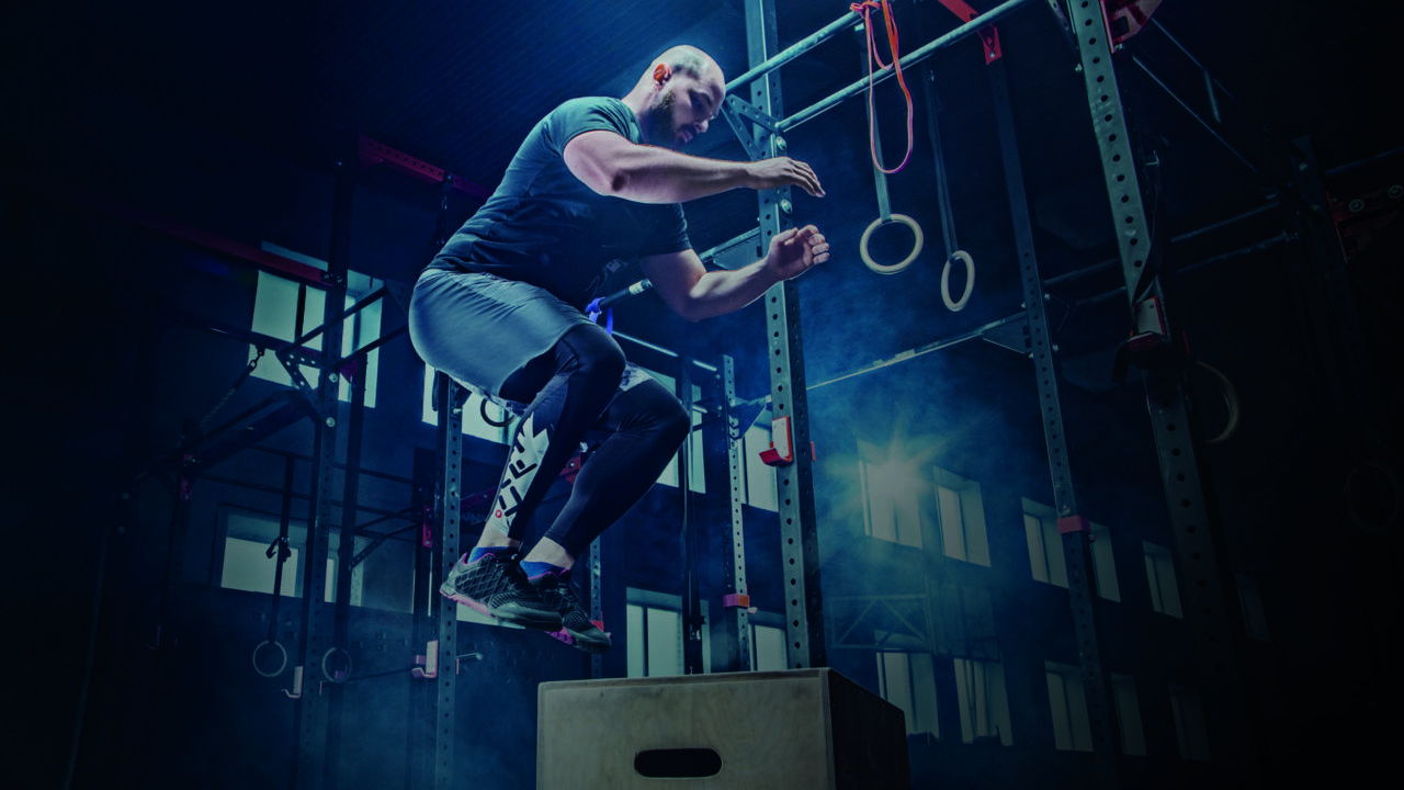 man performing box jump in a gym
