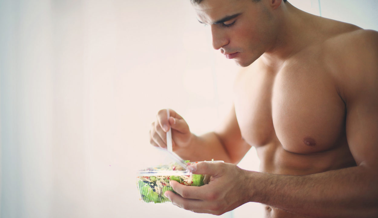 muscular man eating a salad