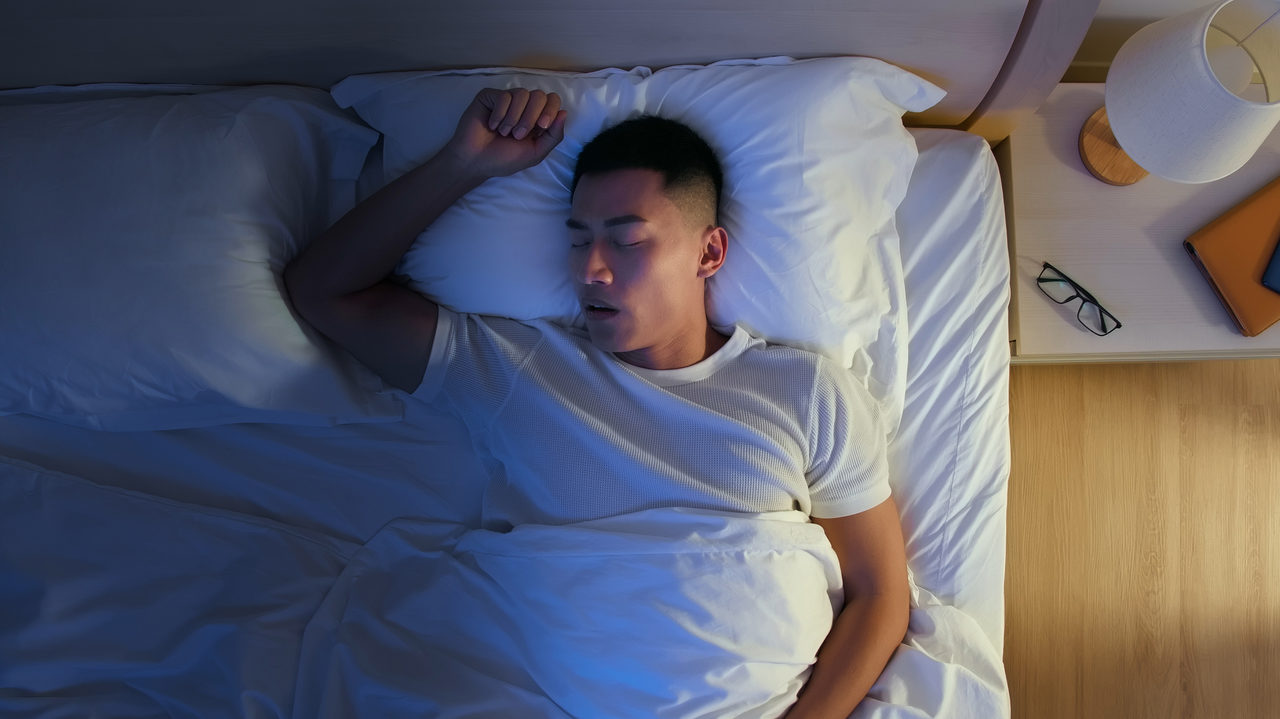 man sleeping in bed with white tshirt on