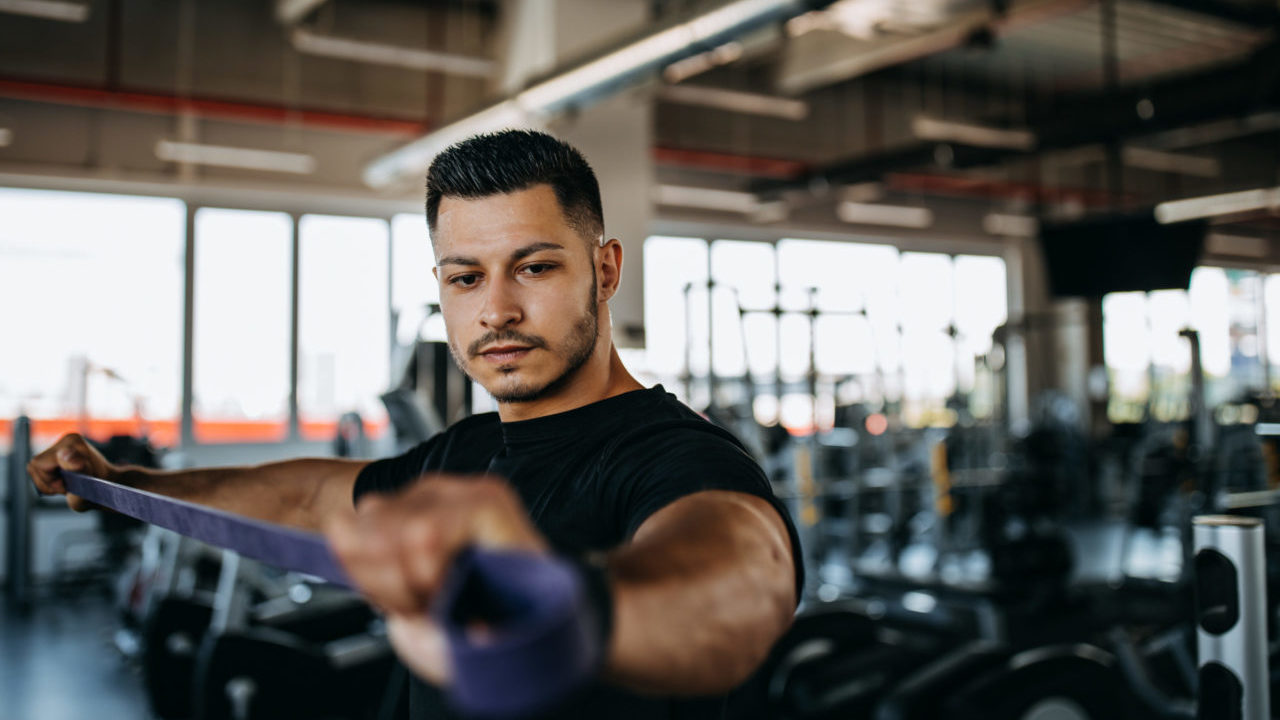 Focused man working out with a resistance band